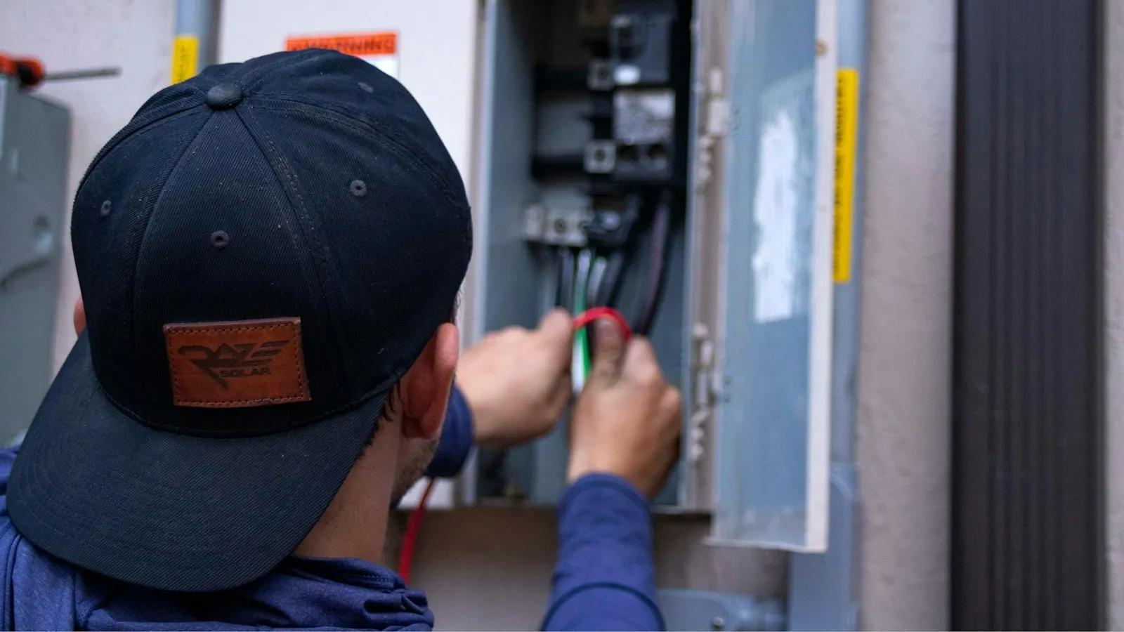A technician checking wiring in a home's electrical panel